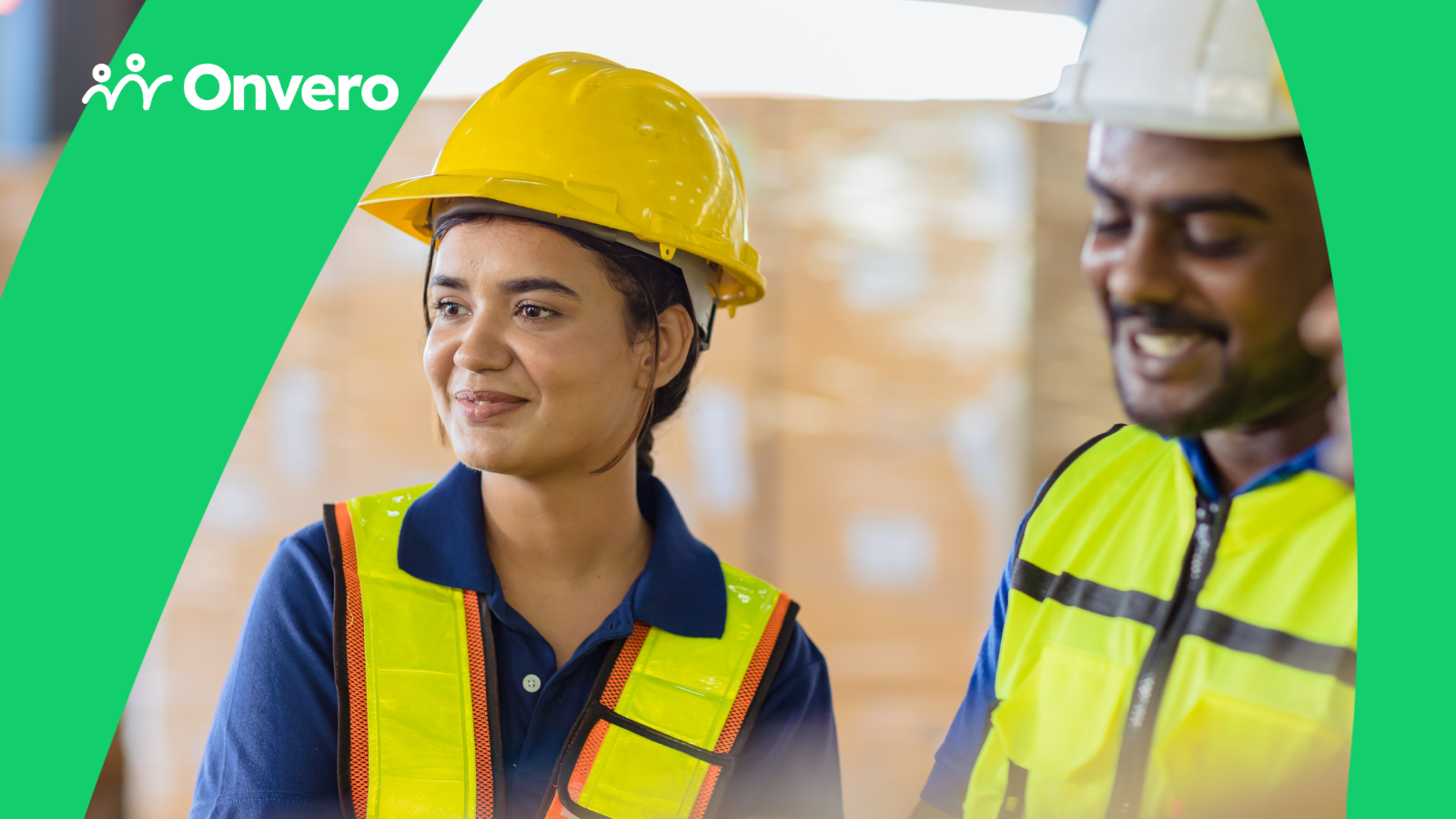 The image shows three people, one female, wearing hard hats and safety vests, standing in what appears to be an industrial or warehouse setting.