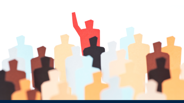 Abstract image of various figures in different muted colours, with one in red at the back with their hand held up, seeming to stand out against all the other colours.