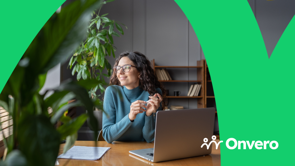 The image features a woman sitting at a desk, looking to her left with a serene smile. In front of her is an open laptop and a sheet of paper with some text on it. A large green leaf is visible in the foreground on the left, partially out of focus, which adds depth to the peaceful scene. The Onvero logo is displayed in the bottom right corner.